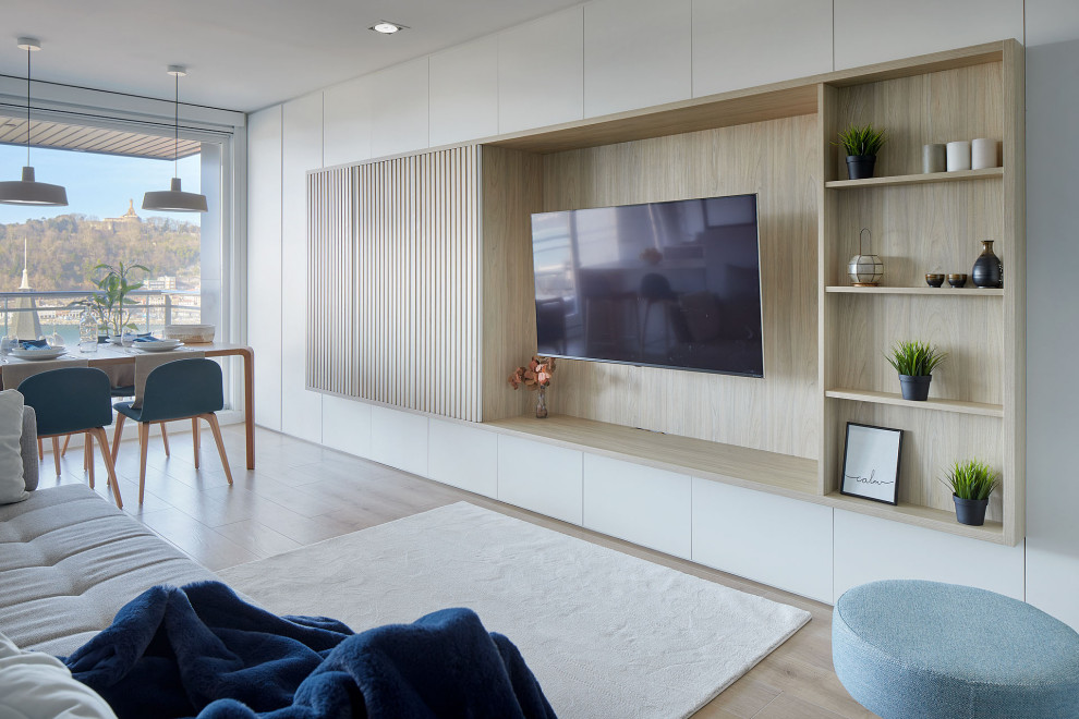 Imagen de salón abierto, blanco y blanco y madera nórdico con paredes blancas, suelo de baldosas de porcelana, televisor colgado en la pared y alfombra