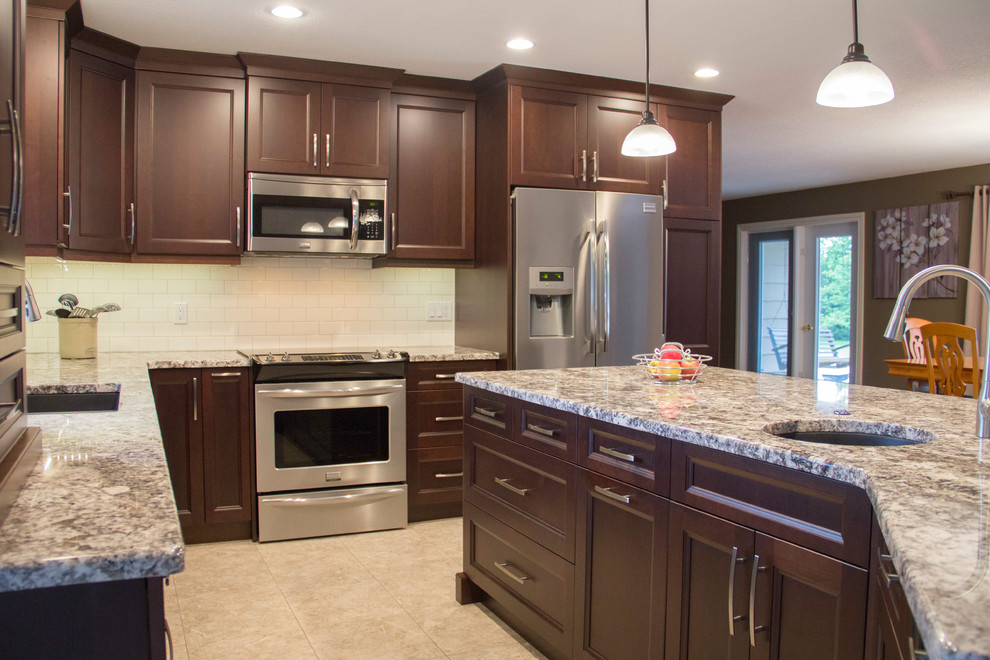 Large transitional l-shaped eat-in kitchen photo with an undermount sink, shaker cabinets, medium tone wood cabinets, granite countertops, white backsplash, stainless steel appliances and an island