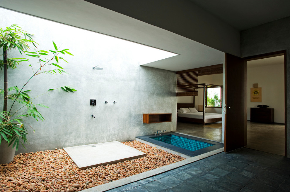 Design ideas for an asian master bathroom in Bengaluru with a drop-in tub, an open shower, blue tile and grey walls.