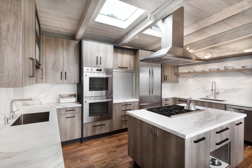 Photo of a large country u-shaped eat-in kitchen in San Francisco with an integrated sink, flat-panel cabinets, light wood cabinets, white splashback, stainless steel appliances, medium hardwood floors and with island.