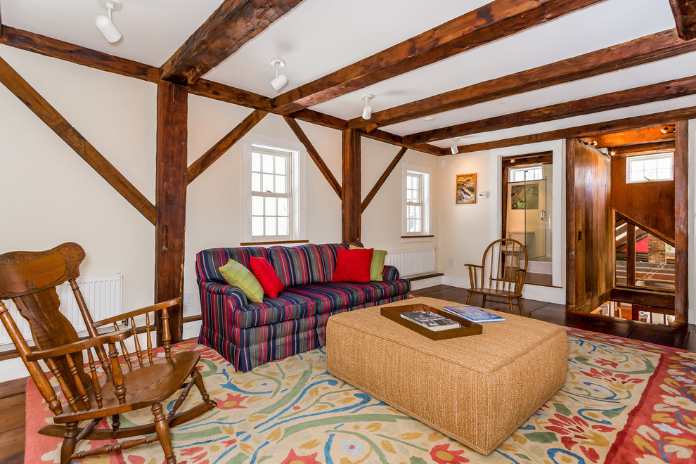 Example of a country enclosed dark wood floor and brown floor family room design in Boston with white walls