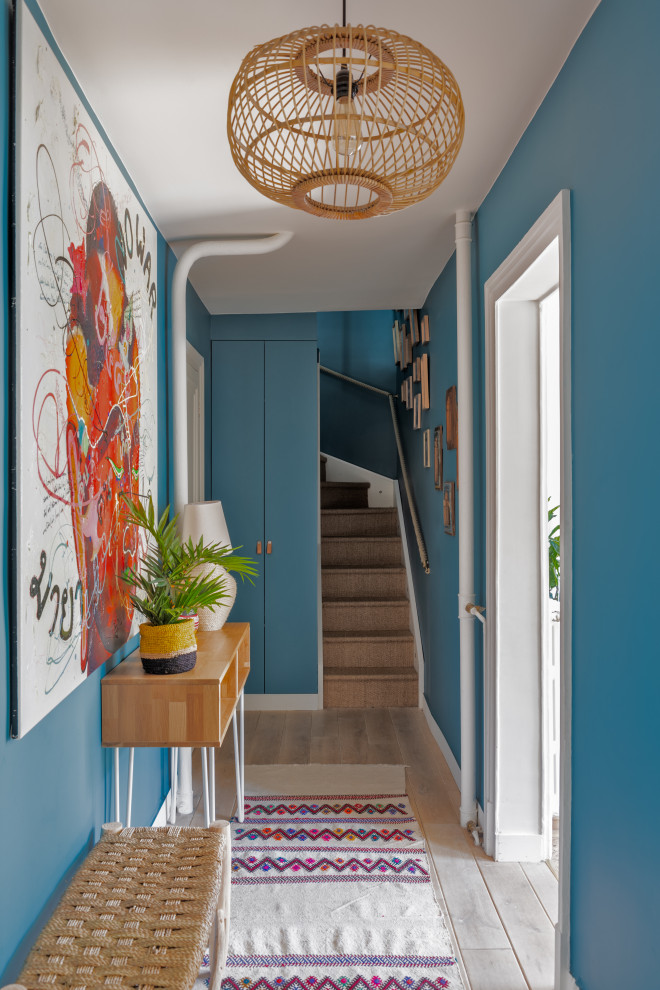Inspiration för eklektiska hallar, med blå väggar, mellanmörkt trägolv och brunt golv