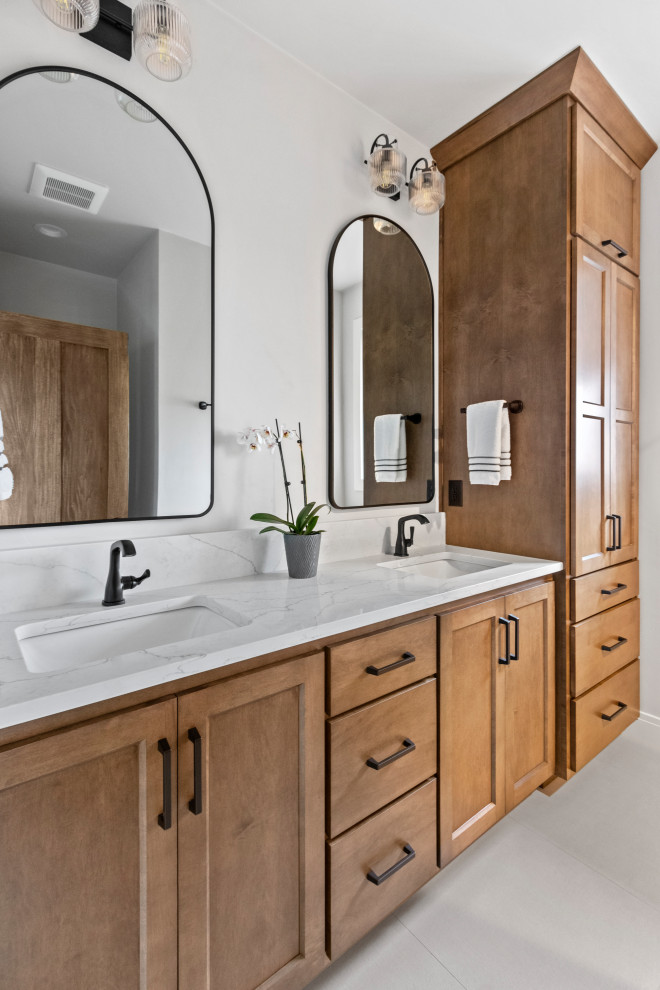 Inspiration for a mid-sized transitional master white tile porcelain tile, white floor and double-sink bathroom remodel with shaker cabinets, brown cabinets, white walls, an undermount sink, quartz countertops, white countertops and a built-in vanity