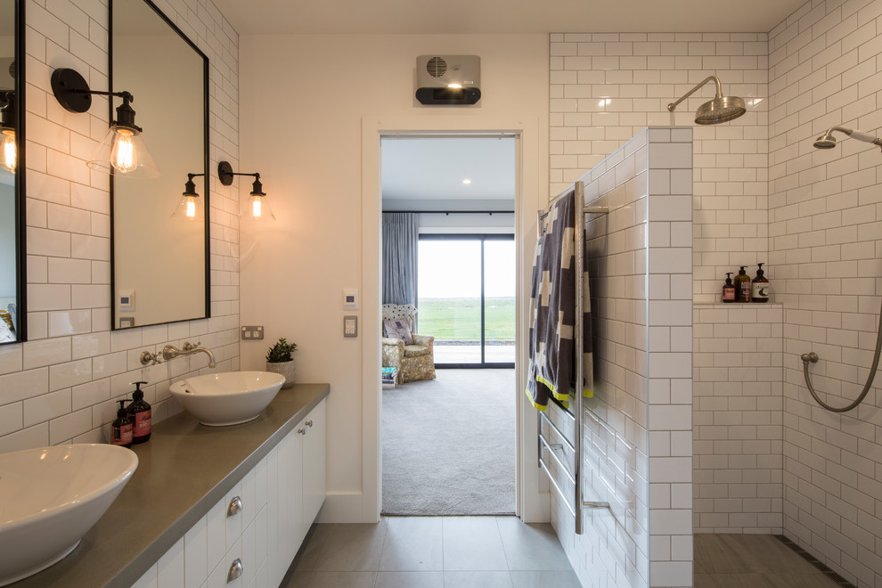 This is an example of a mid-sized contemporary master bathroom in Other with flat-panel cabinets, white cabinets, a curbless shower, white tile, subway tile, white walls, ceramic floors, a vessel sink, concrete benchtops, grey floor, an open shower and grey benchtops.