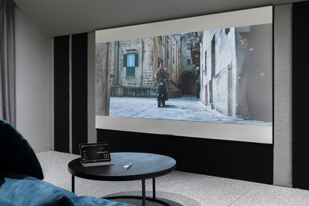 На фото: маленький изолированный домашний кинотеатр в современном стиле с серыми стенами, ковровым покрытием, проектором и серым полом для на участке и в саду
