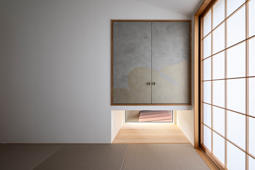 Réalisation d'une chambre d'amis minimaliste avec un mur blanc, un sol de tatami et un sol marron.