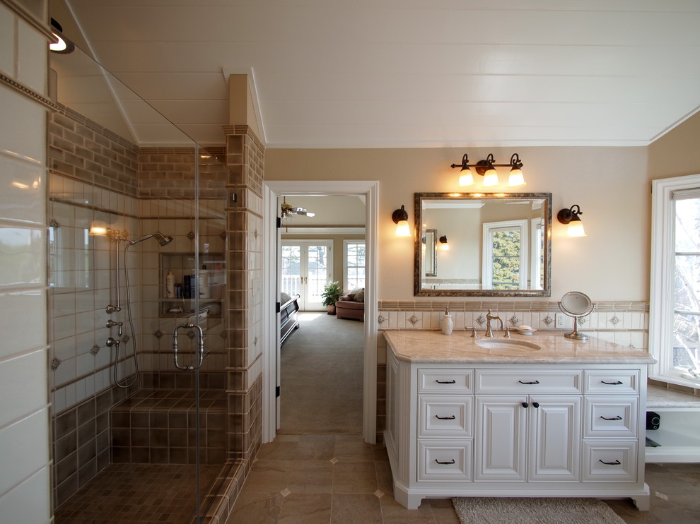 This is an example of a large transitional master bathroom in San Francisco with recessed-panel cabinets, white cabinets, a freestanding tub, an alcove shower, a two-piece toilet, beige tile, brown tile, white tile, cement tile, beige walls, porcelain floors, an undermount sink, granite benchtops, brown floor and a hinged shower door.