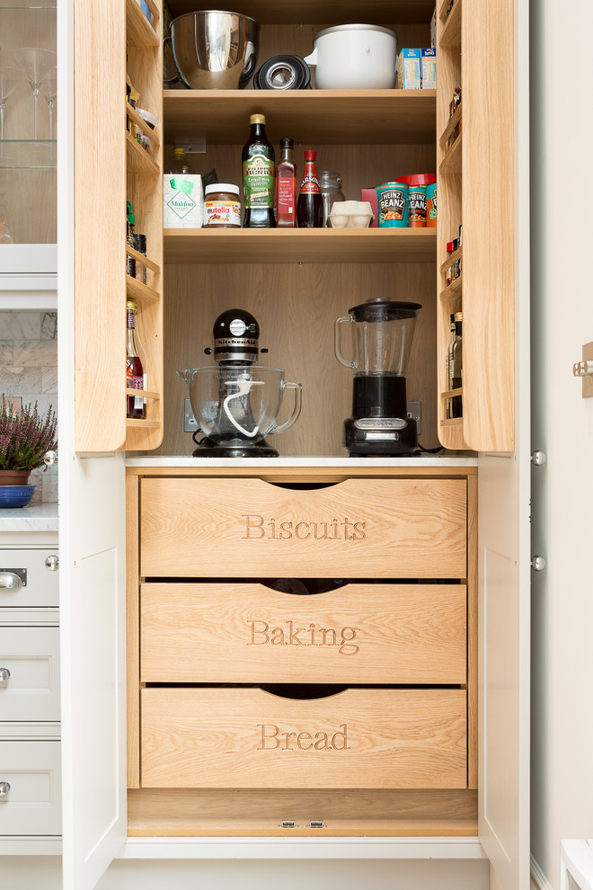 Inspiration for a traditional kitchen pantry in London with shaker cabinets and white cabinets.