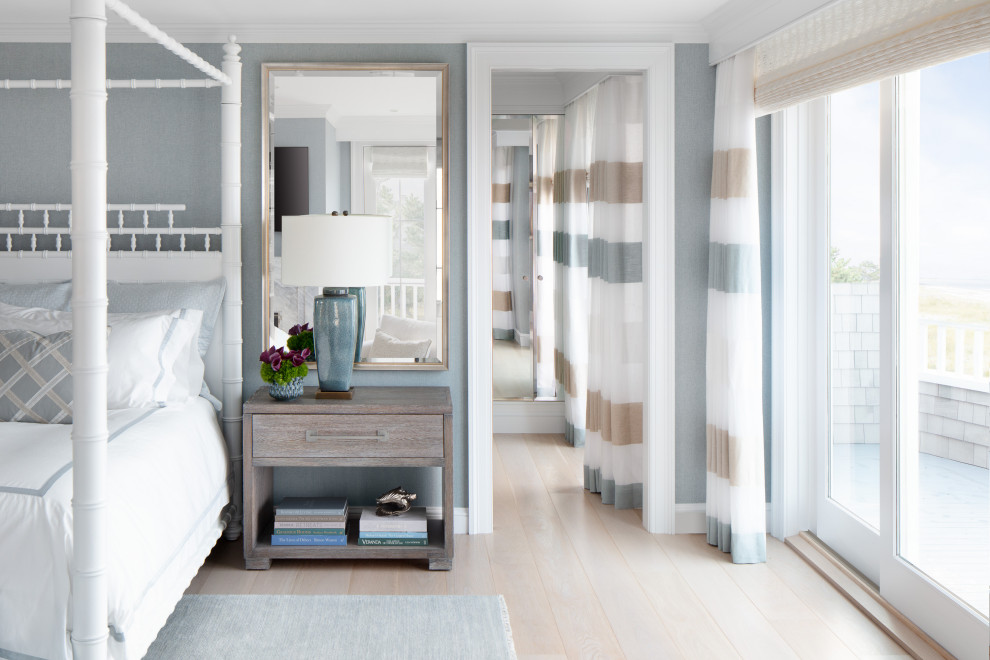 Imagen de dormitorio principal contemporáneo grande con paredes azules, suelo de madera clara, suelo beige y papel pintado