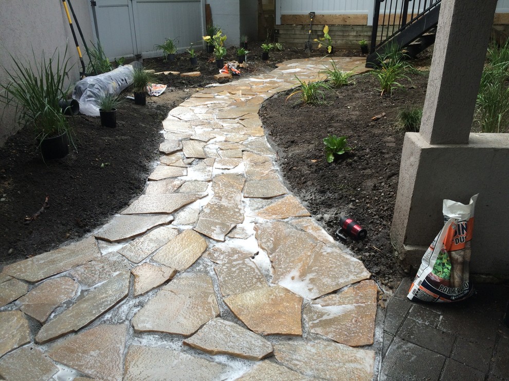 This is an example of a small transitional shade stone landscaping in Calgary.