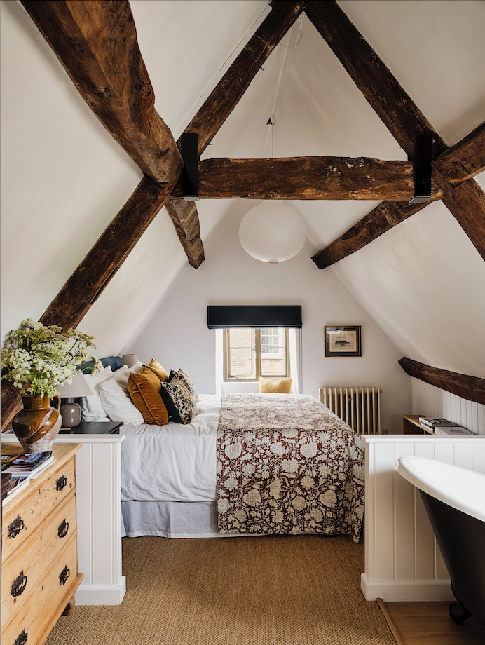 Large country master carpeted, brown floor and exposed beam bedroom photo in Oxfordshire with white walls