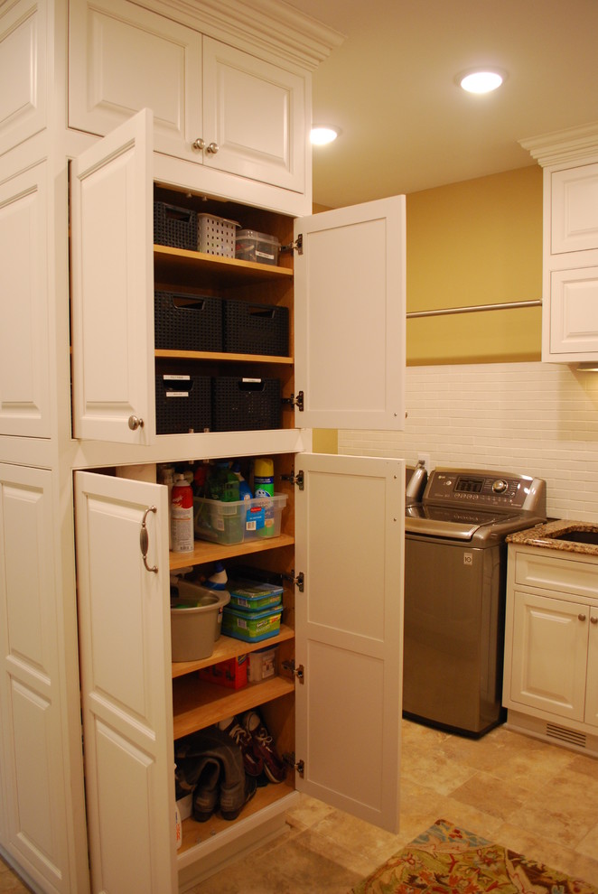 Inspiration for a large traditional u-shaped utility room in Cleveland with an undermount sink, raised-panel cabinets, white cabinets, quartz benchtops, yellow walls, porcelain floors and a side-by-side washer and dryer.