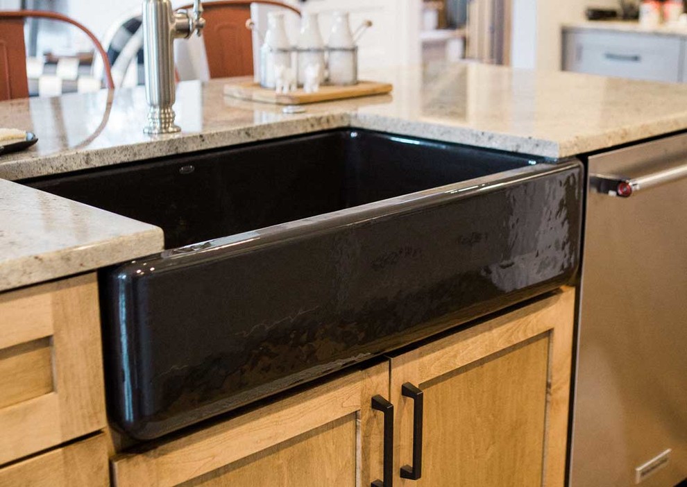 Mid-sized transitional kitchen photo with a farmhouse sink, granite countertops, gray backsplash, stainless steel appliances and an island