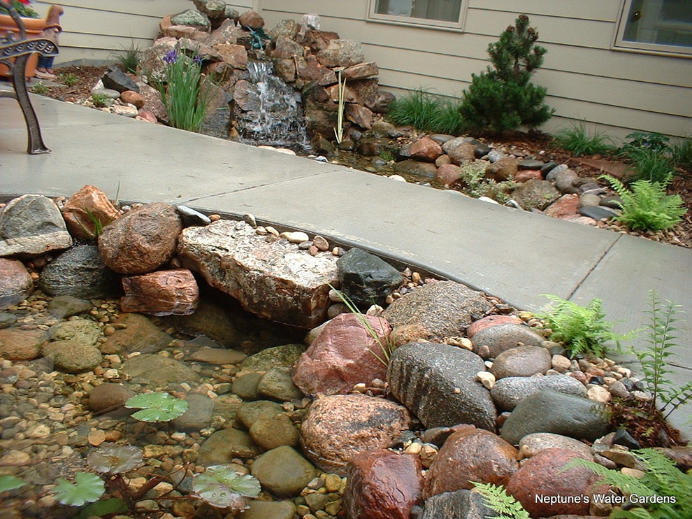 This is an example of a large country garden in Omaha with a water feature.