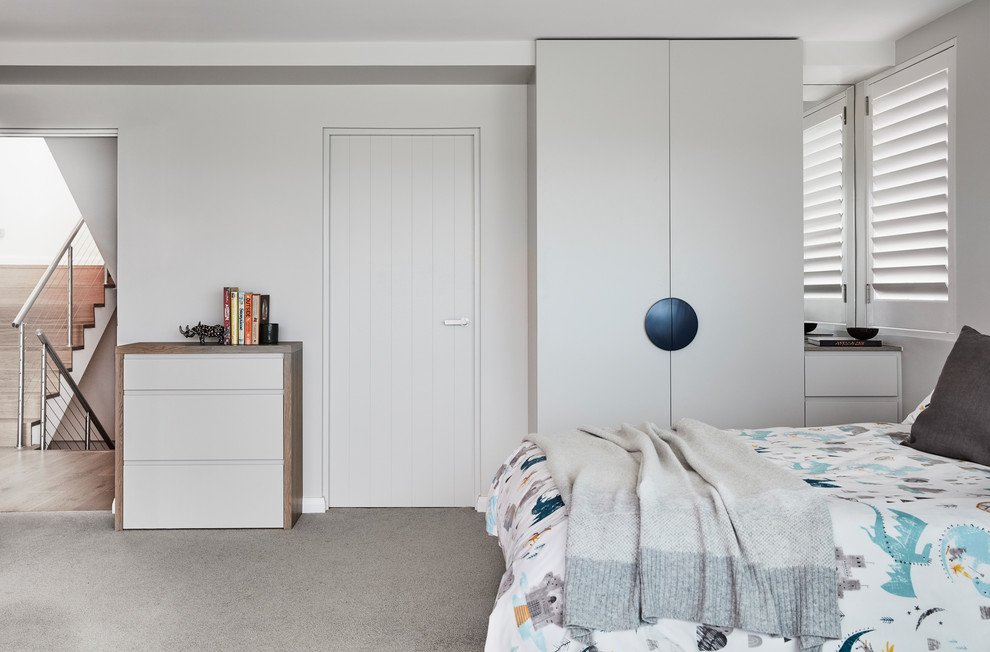 This is an example of a mid-sized contemporary kids' bedroom for kids 4-10 years old and boys in Sydney with grey walls, carpet and grey floor.