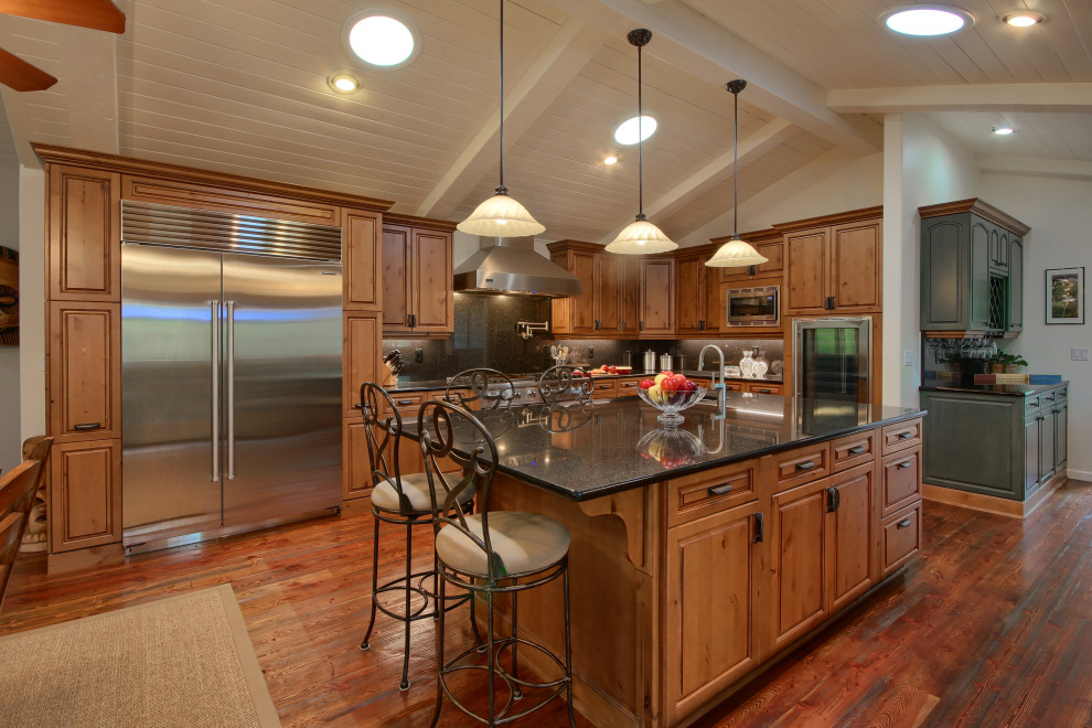 Inspiration for a transitional u-shaped medium tone wood floor, brown floor, exposed beam and shiplap ceiling eat-in kitchen remodel in Other with an undermount sink, raised-panel cabinets, medium tone wood cabinets, quartz countertops, black backsplash, stainless steel appliances, an island and black countertops