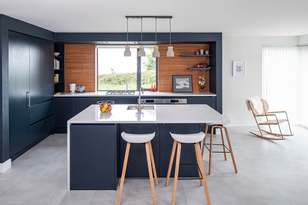 Contemporary l-shaped open plan kitchen in Other with an undermount sink, flat-panel cabinets, grey cabinets, brown splashback, with island, grey floor and white benchtop.