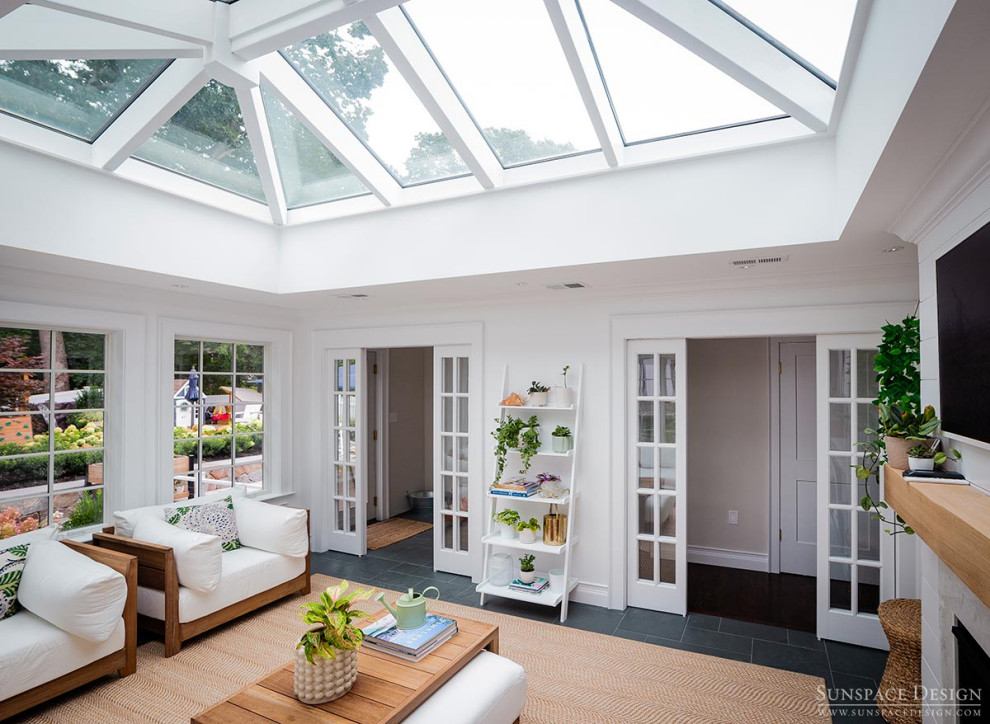Photo of a mid-sized traditional sunroom in Boston with slate floors, a standard fireplace, a stone fireplace surround, a glass ceiling and black floor.