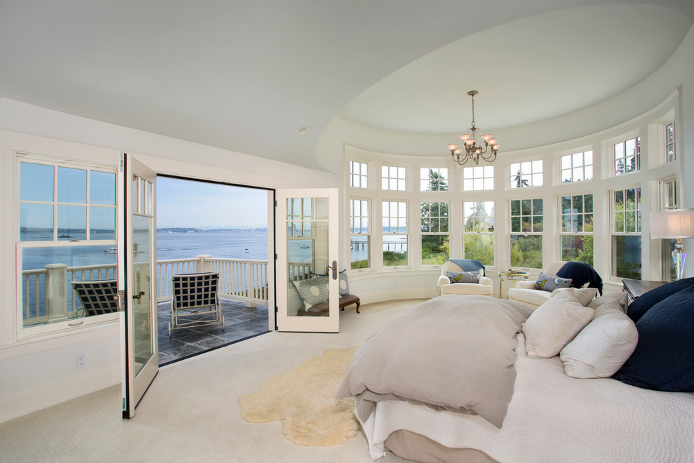 Large beach style master bedroom in Seattle with white walls and carpet.