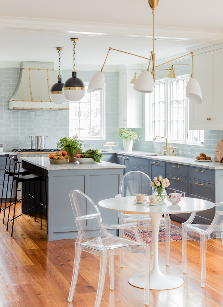 This is an example of a transitional u-shaped eat-in kitchen in Boston with an undermount sink, shaker cabinets, grey cabinets, marble benchtops, grey splashback, subway tile splashback, panelled appliances, medium hardwood floors, with island, brown floor, grey benchtop and exposed beam.