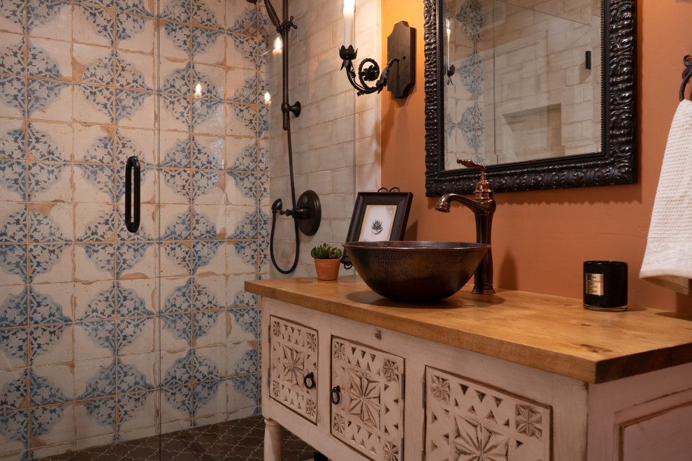 Exempel på ett litet medelhavsstil brun brunt badrum med dusch, med möbel-liknande, vita skåp, en dusch i en alkov, en toalettstol med hel cisternkåpa, beige kakel, porslinskakel, orange väggar, vinylgolv, ett fristående handfat, träbänkskiva, beiget golv och dusch med gångjärnsdörr