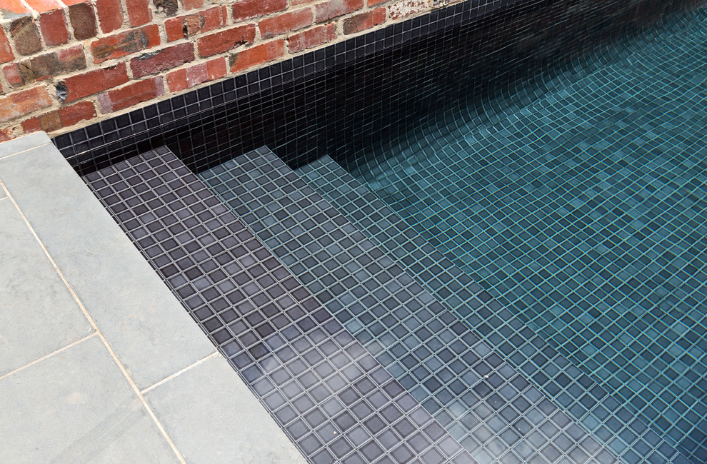 Photo of a small contemporary courtyard rectangular aboveground pool in Melbourne with a water feature and decking.