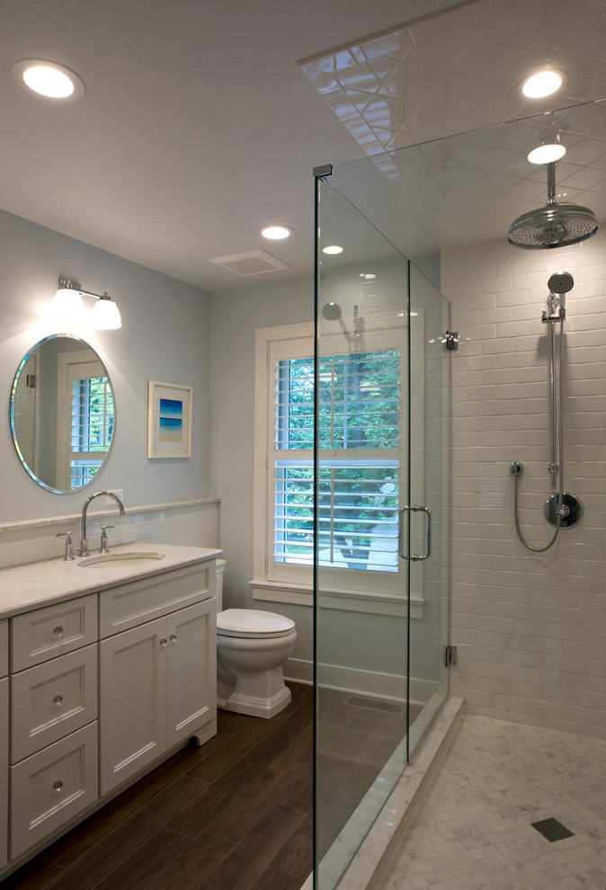 Example of a mid-sized transitional master white tile and subway tile porcelain tile corner shower design in Chicago with recessed-panel cabinets, white cabinets, a two-piece toilet, gray walls, an undermount sink and quartz countertops