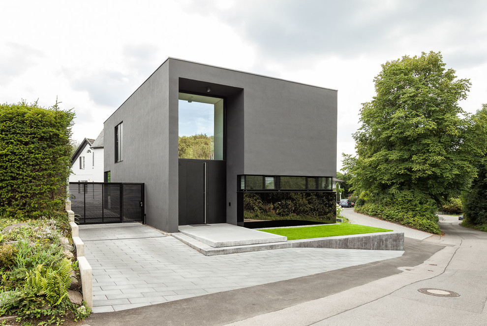 Photo of a mid-sized contemporary two-storey grey exterior in Cologne with mixed siding and a flat roof.