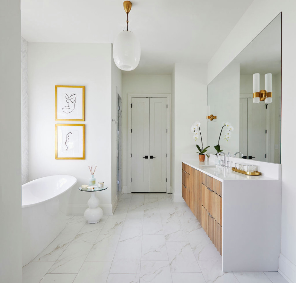 Пример оригинального дизайна: большая главная ванная комната в современном стиле с белыми стенами, мраморным полом, врезной раковиной, тумбой под одну раковину, белыми фасадами, отдельно стоящей ванной, белым полом, душем с распашными дверями, белой столешницей и встроенной тумбой