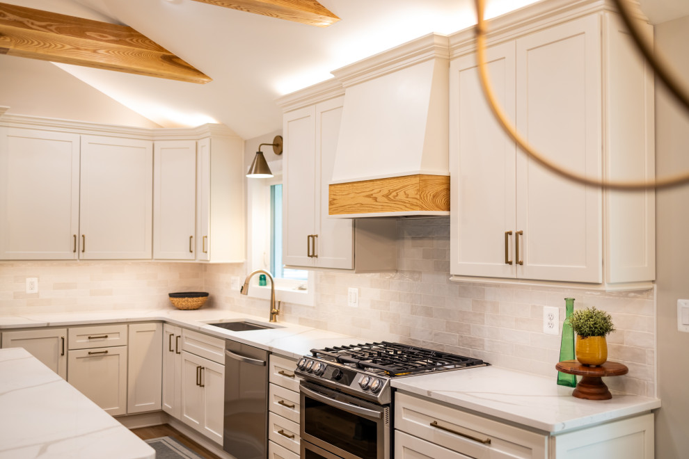 Eat-in kitchen - large transitional l-shaped light wood floor, brown floor and exposed beam eat-in kitchen idea in DC Metro with an undermount sink, shaker cabinets, quartz countertops, white backsplash, porcelain backsplash, stainless steel appliances, an island and white countertops