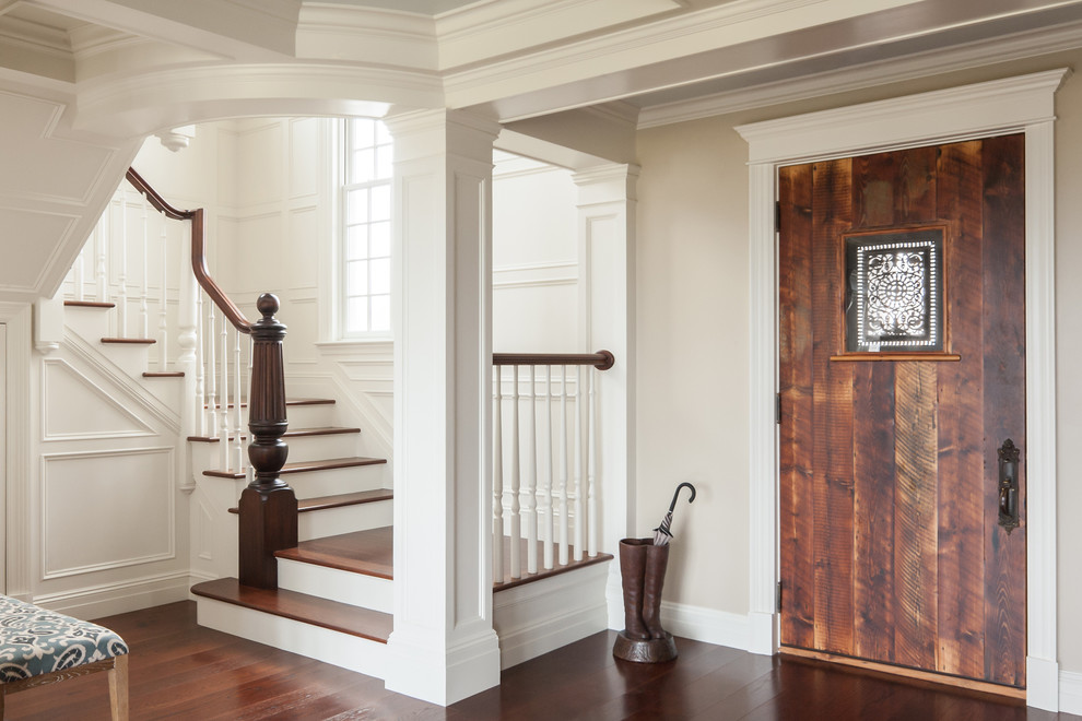 This is an example of a large traditional foyer in Portland Maine with beige walls, dark hardwood floors, a single front door, a dark wood front door and brown floor.