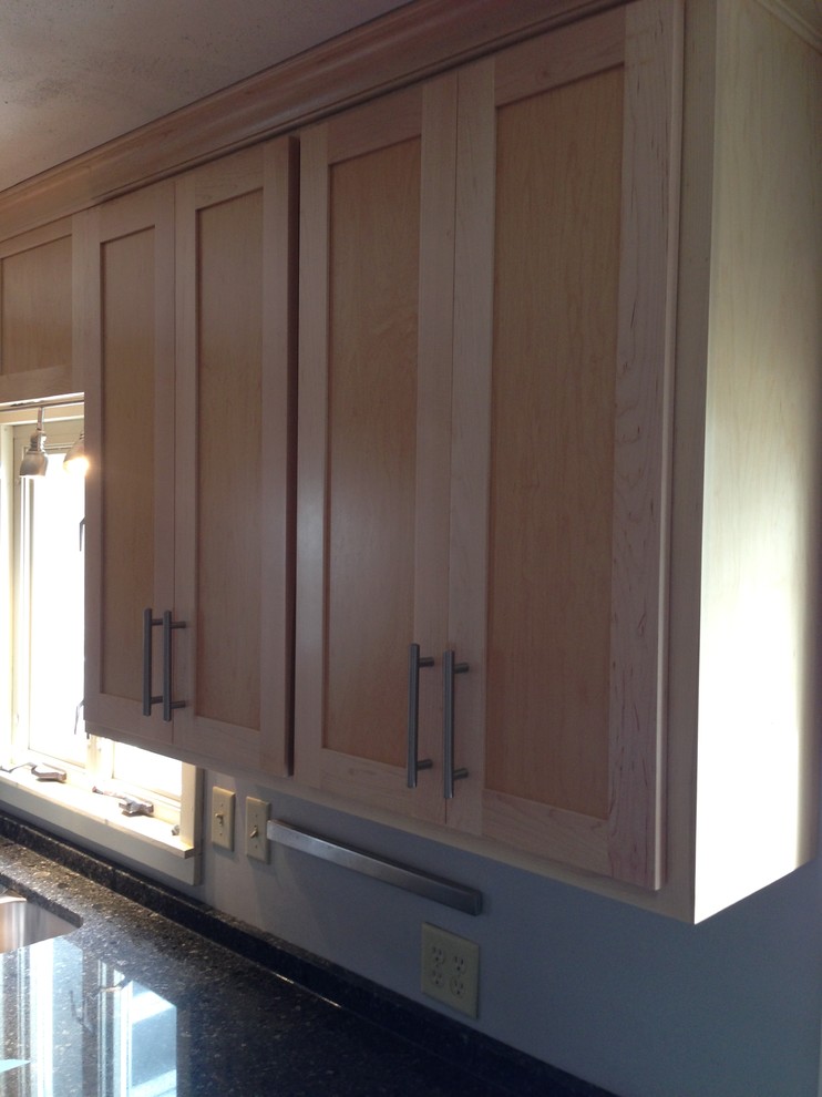 Small transitional u-shaped medium tone wood floor enclosed kitchen photo in Chicago with a double-bowl sink, shaker cabinets, light wood cabinets, quartzite countertops, stainless steel appliances and a peninsula