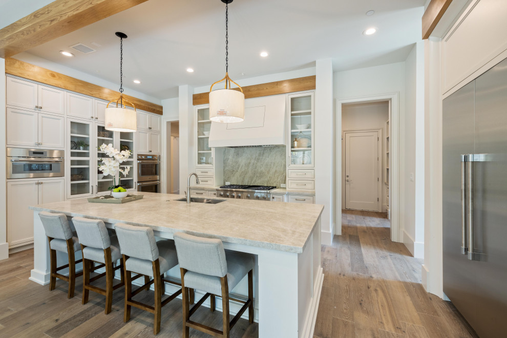 Enclosed kitchen - huge transitional u-shaped medium tone wood floor, brown floor and exposed beam enclosed kitchen idea in Houston with an integrated sink, beaded inset cabinets, white cabinets, quartz countertops, gray backsplash, stainless steel appliances, an island and beige countertops