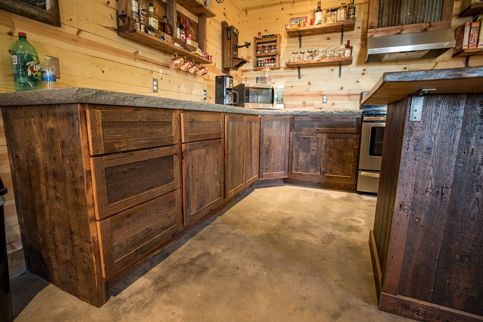 Design ideas for a small country u-shaped eat-in kitchen in Wichita with a farmhouse sink, shaker cabinets, distressed cabinets, concrete benchtops, brown splashback, timber splashback, stainless steel appliances, concrete floors, with island and grey floor.