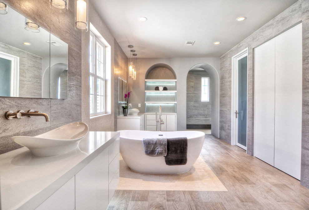 Inspiration for an expansive midcentury master bathroom in Orange County with flat-panel cabinets, white cabinets, a freestanding tub, an open shower, a one-piece toilet, gray tile, ceramic tile, grey walls, ceramic floors, a vessel sink and engineered quartz benchtops.