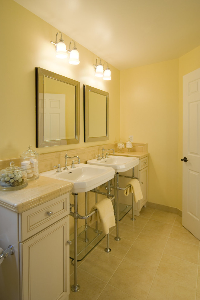 This is an example of a mid-sized traditional kids bathroom in San Francisco with recessed-panel cabinets, red cabinets, a shower/bathtub combo, a two-piece toilet, ceramic tile, yellow walls, ceramic floors, a pedestal sink, tile benchtops and beige tile.