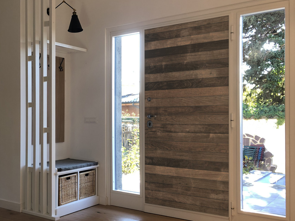 Ejemplo de puerta principal grande con paredes blancas, suelo laminado, puerta simple y puerta de madera clara