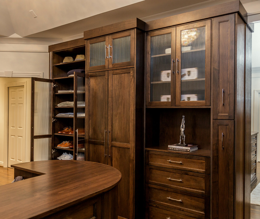 Photo of a large arts and crafts gender-neutral dressing room in Louisville with shaker cabinets, dark wood cabinets, medium hardwood floors and brown floor.