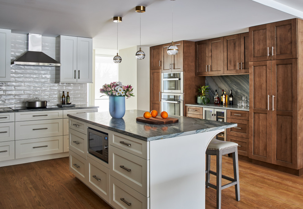 Exempel på ett mellanstort klassiskt grå grått kök, med släta luckor, vita skåp, bänkskiva i kvartsit, grått stänkskydd, stänkskydd i porslinskakel, rostfria vitvaror, mellanmörkt trägolv och en köksö