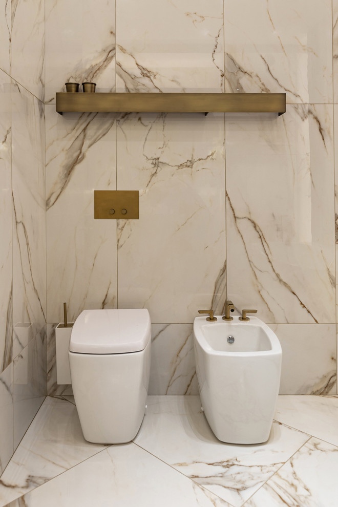 This is an example of a mid-sized contemporary master bathroom in Saint Petersburg with flat-panel cabinets, a freestanding tub, beige tile, marble, beige walls, marble floors, a wall-mount sink, marble benchtops, beige floor and multi-coloured benchtops.