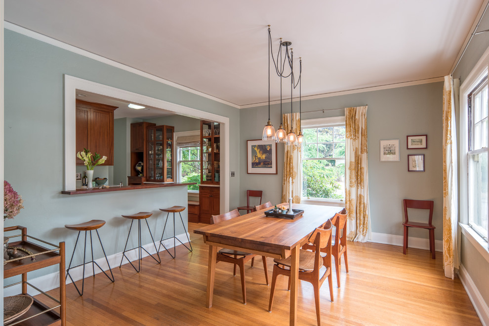This is an example of a transitional dining room in Portland with grey walls, medium hardwood floors and brown floor.
