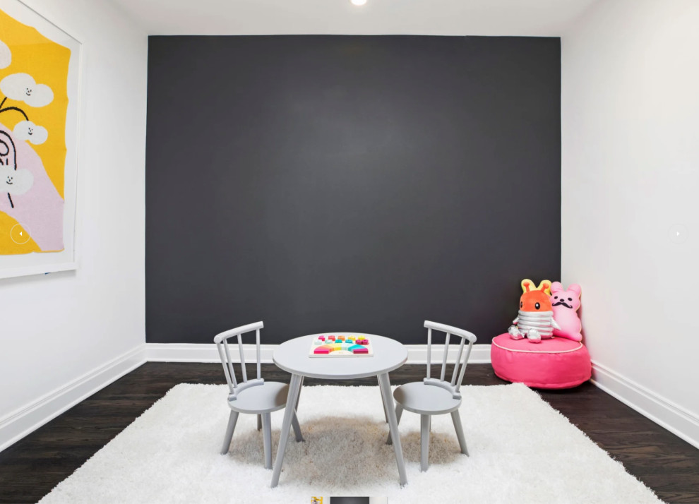 Photo of a mid-sized modern gender-neutral kids' room in Los Angeles with white walls, dark hardwood floors and white floor.