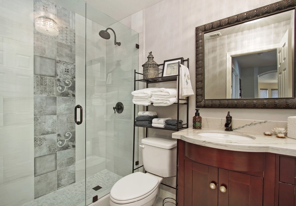 Photo of a small transitional bathroom in San Diego with flat-panel cabinets, medium wood cabinets, a two-piece toilet, gray tile, porcelain tile, white walls, porcelain floors, an undermount sink and engineered quartz benchtops.
