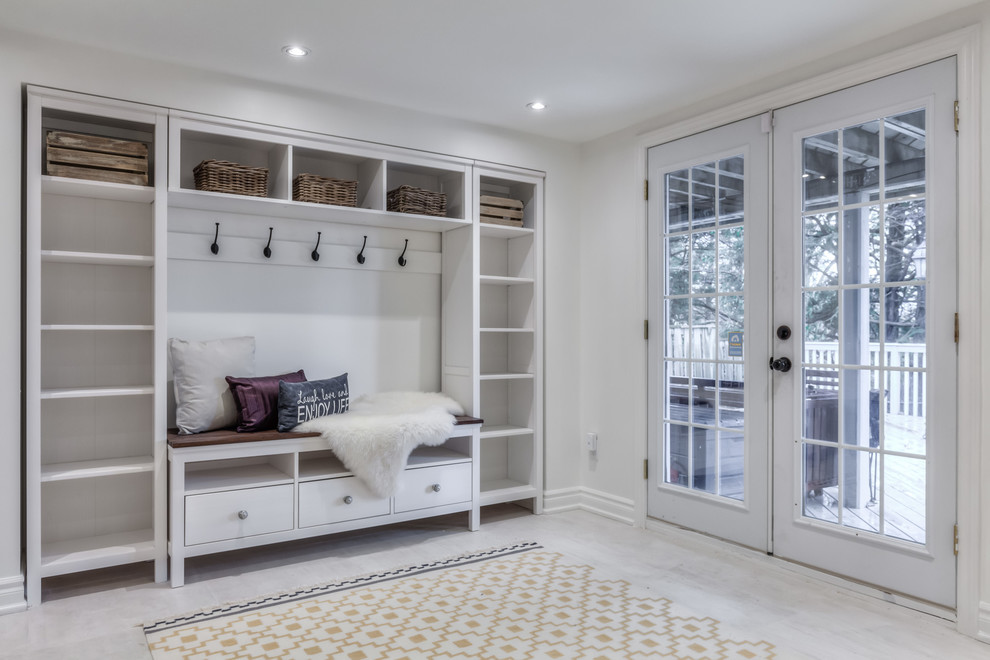 Photo of a mid-sized beach style mudroom in Toronto with white walls and laminate floors.