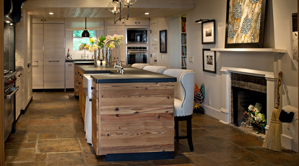 Country kitchen in Other with flat-panel cabinets, a farmhouse sink, stainless steel appliances and light wood cabinets.