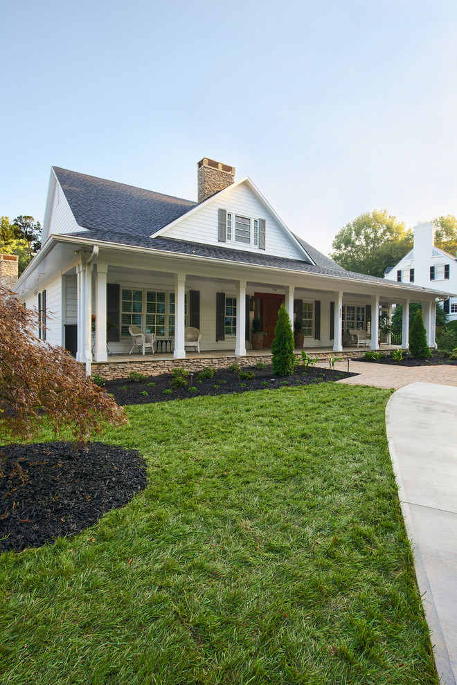 Large traditional two-storey white exterior in Raleigh with wood siding and a hip roof.