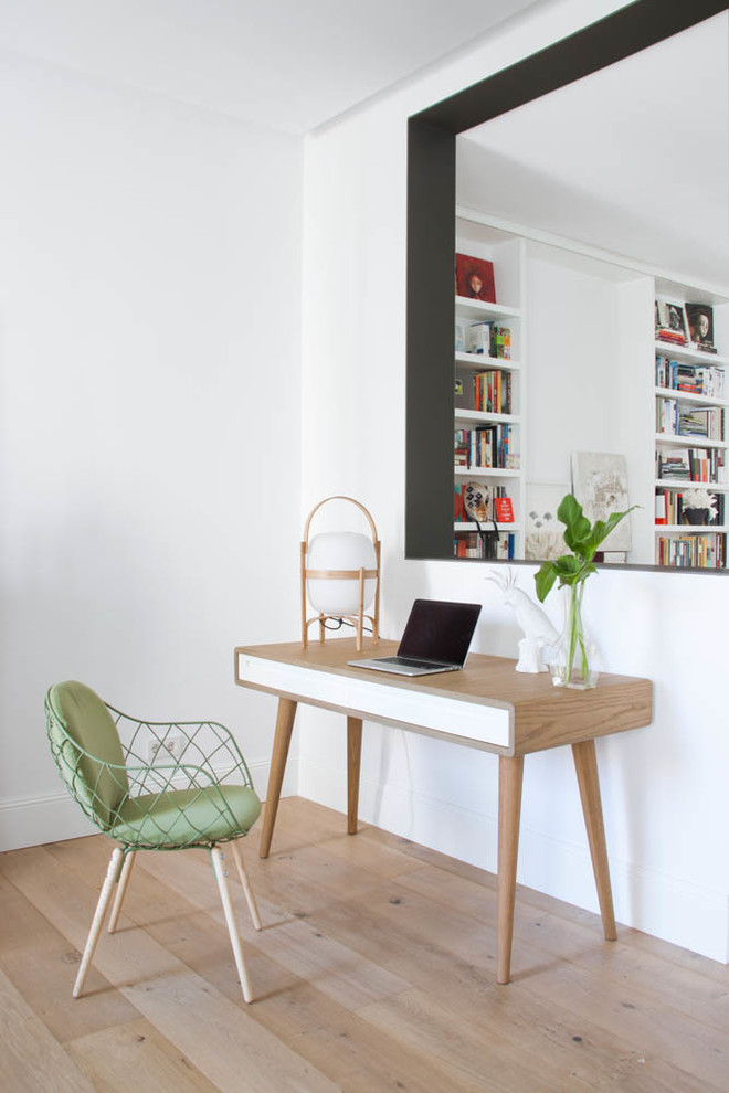 Inspiration for a mid-sized scandinavian study room in Madrid with white walls, light hardwood floors, no fireplace and a freestanding desk.