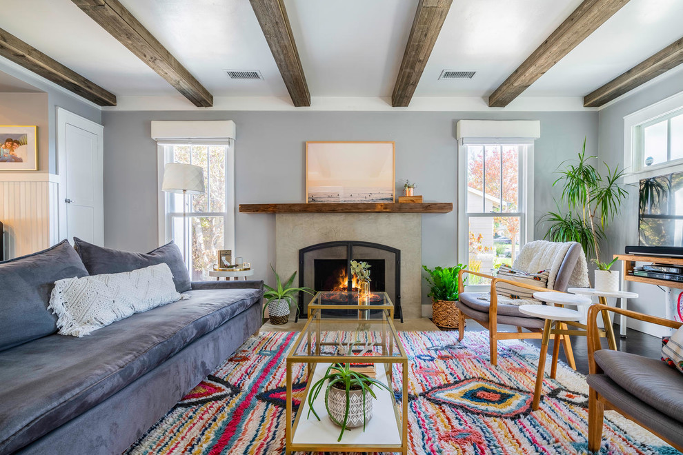 Inspiration for a mid-sized eclectic formal open concept living room in Los Angeles with grey walls, dark hardwood floors, a standard fireplace, a concrete fireplace surround, a freestanding tv and brown floor.