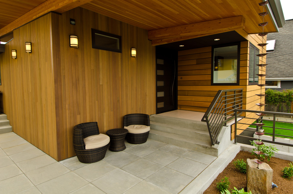 This is an example of a contemporary verandah in Seattle with a roof extension.
