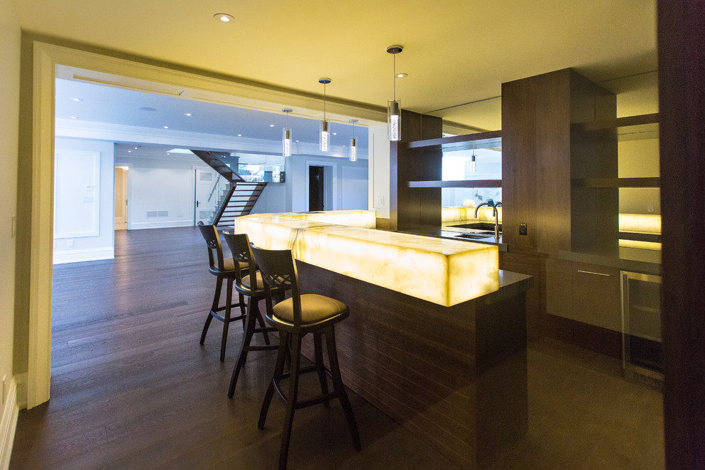 Inspiration for a large transitional u-shaped seated home bar in Toronto with an undermount sink, open cabinets, brown cabinets, onyx benchtops, mirror splashback, dark hardwood floors and brown floor.